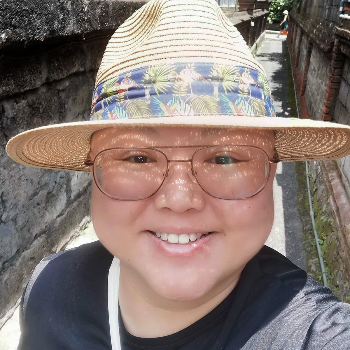 Portrait of Eileena Lee wearing a straw hat and smiling